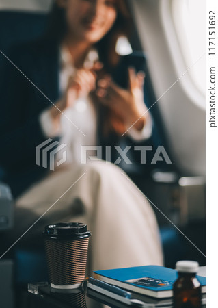 Asian woman sitting in a seat in airplane and looking out the window going on a trip vacation travel concept.Capture the allure of wanderlust with this stunning image 117151692