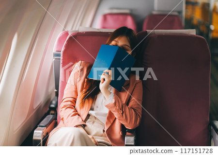 Tired asian woman with headache feeling sick while sitting in the airplane , Passengers near the window. 117151728