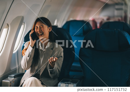 Asian woman sitting in a seat in airplane and looking out the window going on a trip vacation travel concept.Capture the allure of wanderlust with this stunning image 117151732