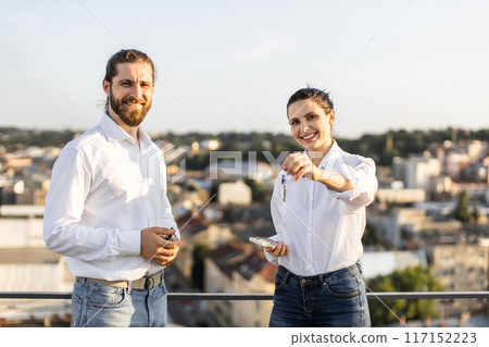 Happy couple celebrating new home purchase on rooftop Happy couple celebrating new home purchase on rooftop 117152223