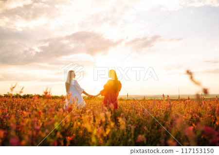 Two Beautiful woman in a field. Nature, fashion, vacation and lifestyle. Two Beautiful woman in a field. Nature, fashion, vacation and lifestyle. 117153150