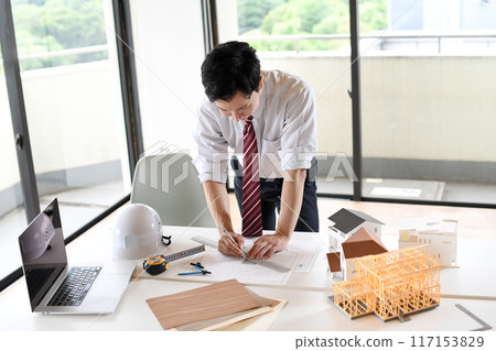 A male business person designing a building A male business person designing a building 117153829