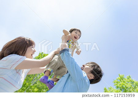 Parents holding their son in the park 117153959