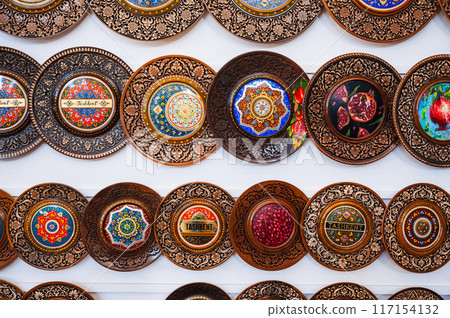 traditional Uzbek wooden handmade gift plates with wood carvings hand-painted in market of Uzbekistan traditional Uzbek wooden handmade gift plates with wood carvings hand-painted in market of Uzbekistan 117154132
