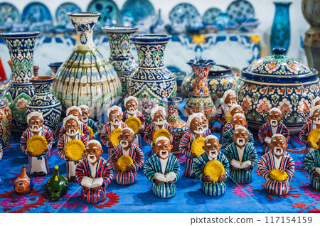 Asian Uzbek statuettes and ceramic vases hand-painted in an oriental market at pottery workshop in Uzbekistan Asian Uzbek statuettes and ceramic vases hand-painted in an oriental market at pottery workshop in Uzbekistan 117154159