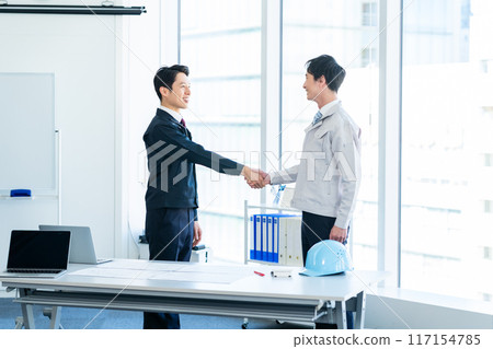 Businessmen in work clothes shaking hands 117154785