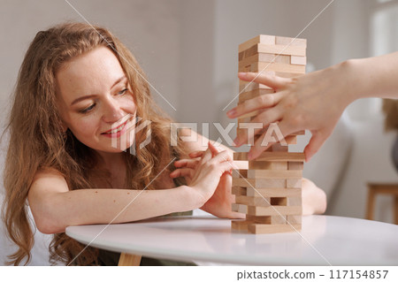 two women playing a board game made of wooden blocks at home, excitement and relaxation, mind development concept, hand motor skills, two women playing a board game made of wooden blocks at home, excitement and relaxation, mind development concept, hand motor skills, 117154857