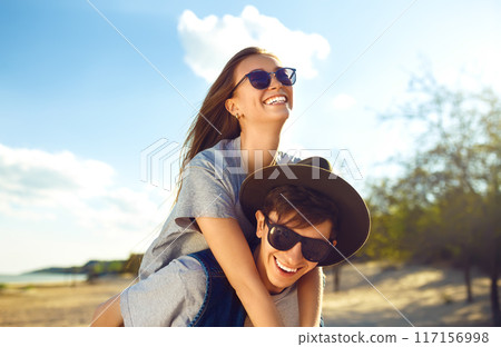 Group of friends enjoying time on beach. Laugh and smile. Friendly atmosphere. Guys enjoy photos. 117156998