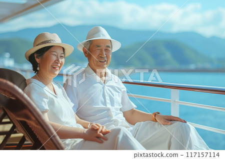 Senior couple sitting on deck chairs on a luxury cruise ship and looking at the sea 117157114