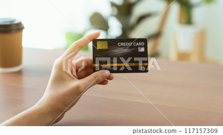 Hand holding credit card for paying products online via the Internet. Hand holding credit card for paying products online via the Internet. 117157309