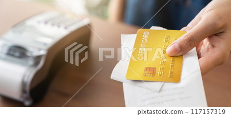 Shop owner holding credit card with bill to customer. Shop owner holding credit card with bill to customer. 117157319