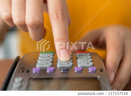 Shop owner hand press on card swipe machine for to pay. 117157338