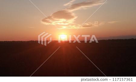 Golden sunset over rural landscape with large cloud, ideal for relaxation and nature enjoyment. Golden sunset over rural landscape with large cloud, ideal for relaxation and nature enjoyment. 117157361