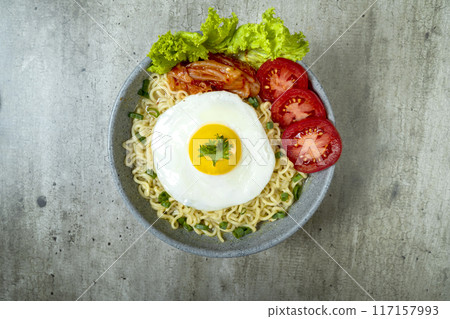 A bowl of instant noodles with eggs, tomatoes, and lettuce A bowl of instant noodles with eggs, tomatoes, and lettuce 117157993