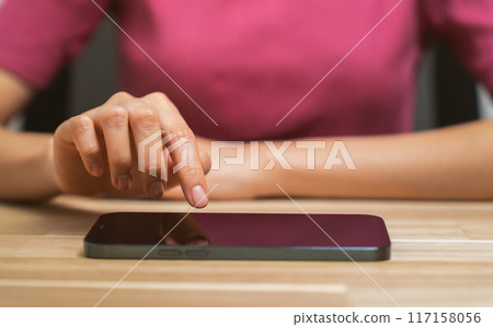 Hand holding smartphone with using social media on internet on table. 117158056