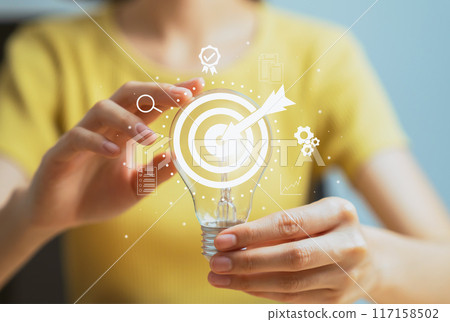 Hand holding light bulb with show target goal on virtual screen, future growth, planning and success business concept 117158502