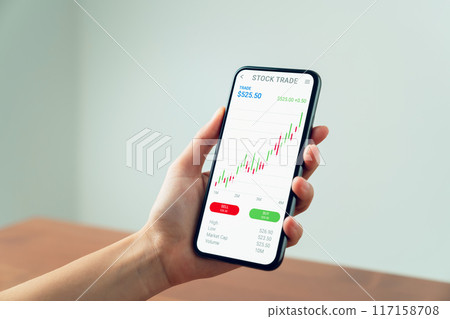 Businessman trader using smartphone with stock market investments and graph on screen to analyze trading data, buy or sell and checking price on mobile application. Businessman trader using smartphone with stock market investments and graph on screen to analyze trading data, buy or sell and checking price on mobile application. 117158708