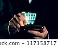 Businessman holding smartphone and showing shopping cart. 117158717