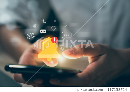 Hand using smartphone with showing the bell icon and notifications of new messages on application. Hand using smartphone with showing the bell icon and notifications of new messages on application. 117158724