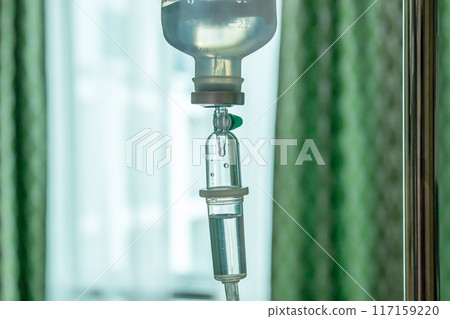 Close up medical intravenous IV drip in hospital background 117159220