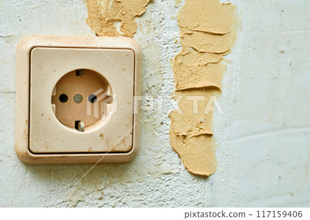 Old dirty electrical socket on the wall before renovation 117159406