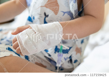 Close up child hand with saline IV solution in hospital Close up child hand with saline IV solution in hospital 117159425