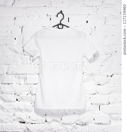 brick whitewashed wall with white t- shirt on hanger 117159960