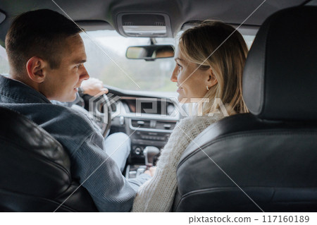 couple driving car and looking at each couple driving car and looking at each 117160189
