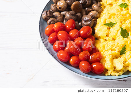 Homemade scrambled eggs with mushrooms and cherry tomatoes Homemade scrambled eggs with mushrooms and cherry tomatoes 117160297