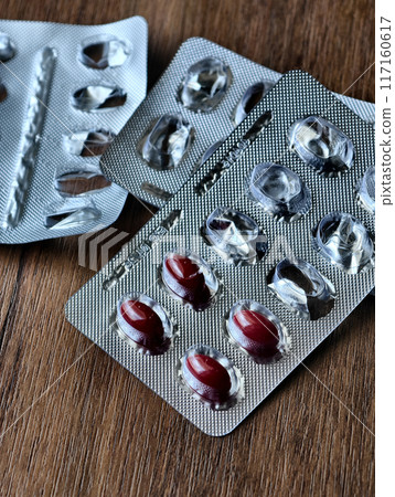 A nearly empty blister packs of pills on a wooden table A nearly empty blister packs of pills on a wooden table 117160617