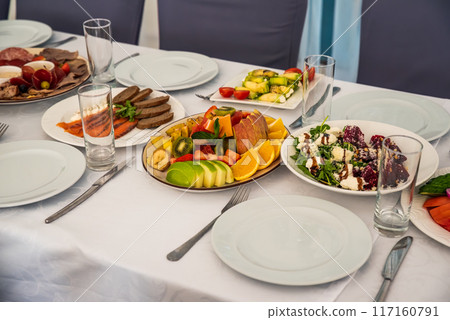 festive table set with Caesar salads, beets, fruit plate without people festive table set with Caesar salads, beets, fruit plate without people 117160791