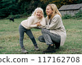 Cheerful carefree mother and little daughter on a walk in the farm.	 117162708