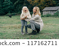 Loving mother tickles her laughing adorable curly little daughter.	 117162711