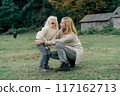 Loving mother tickles her laughing adorable curly little daughter.	 117162713