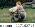 Loving mother tickles her laughing adorable curly little daughter.	 117162714
