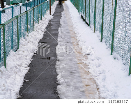 狹窄的人行道撒有融雪劑 狹窄的人行道撒有融雪劑 117163557