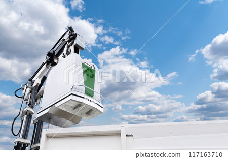 Garbage truck lifts street bin for recyclable waste 117163710