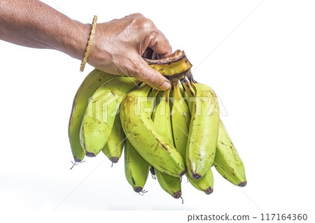Indian woman wearing gold bangle holding bunch of bananas on white background. Closeup Indian woman wearing gold bangle holding bunch of bananas on white background. Closeup 117164360