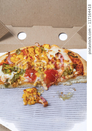 Closeup of leftover pizza in cardboard box on white background. 117164418