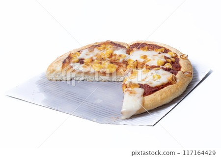 A slice is missing from a vegetarian pizza with corn and mozzarella cheese on a white background. Closeup A slice is missing from a vegetarian pizza with corn and mozzarella cheese on a white background. Closeup 117164429
