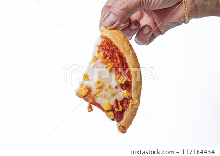Woman's hand holding a slice of vegetarian sweet corn pizza on a white background. Closeup 117164434