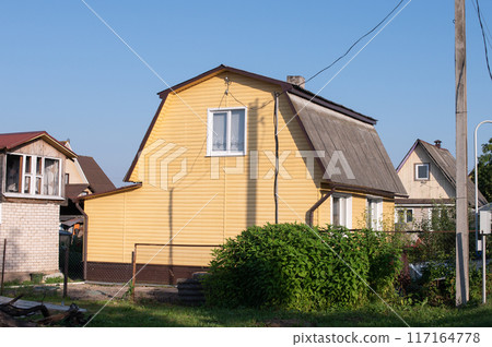 Yellow Wooden House with Greenery in a Suburban Neighborhood Yellow Wooden House with Greenery in a Suburban Neighborhood 117164778