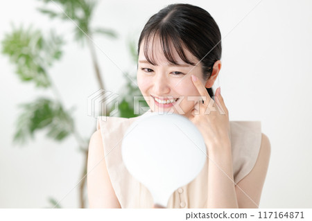 一個女人在手鏡中看著自己的眼睛 117164871