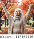 An old woman admiring autumn leaves 117165146