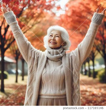 An old woman admiring autumn leaves An old woman admiring autumn leaves 117165146