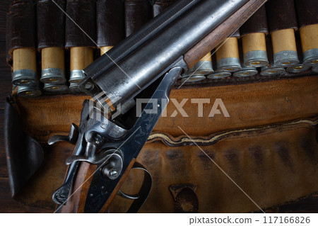 double barreled side shotgun with cartridges in bandolier. double barreled side shotgun with cartridges in bandolier. 117166826