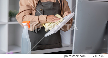 Housekeeper Cleaning Computer Keyboard with Cloth and Spray Bottle in Modern Office Environment Housekeeper Cleaning Computer Keyboard with Cloth and Spray Bottle in Modern Office Environment 117167363