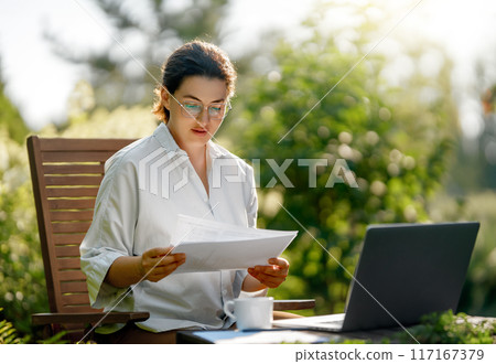 woman working on laptop in summer morning woman working on laptop in summer morning 117167379