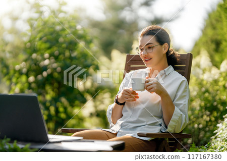 woman working on laptop in summer morning woman working on laptop in summer morning 117167380
