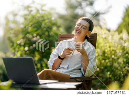 woman working on laptop in summer morning 117167381